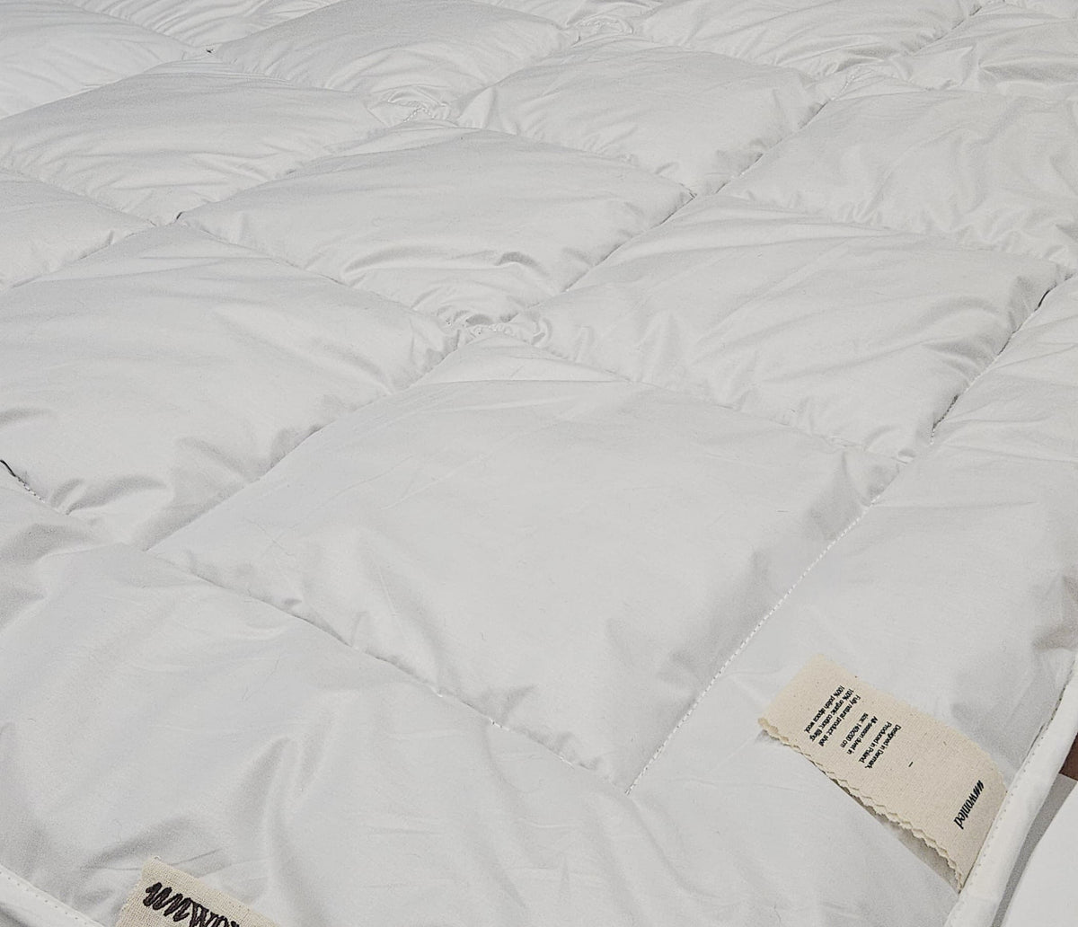 Close-up of the quilted organic cotton shell of an UNWONTED alpaca duvet